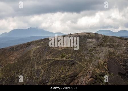 Menschen, die an einem bewölkten Tag auf dem Vulkan Paricutin in Michoacan, Mexiko, spazieren gehen. Stockfoto