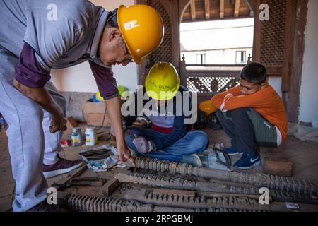191011 -- PEKING, 11. Oktober 2019 -- Zhou Jianguo L weist nepalesische Arbeiter am 10. Oktober 2019 an der Restaurierungsstelle des neunstöckigen Basantapur-Komplexes in Kathmandu, Nepal, an. Zhang Keren Xinhua Schlagzeilen: Chinesische Restaurierungsspezialisten helfen Nepal, die Seele der Kultur des Kathmandu-Tals WangxJingqiang PUBLICATIONxNOTxINxCHN wiederherzustellen Stockfoto