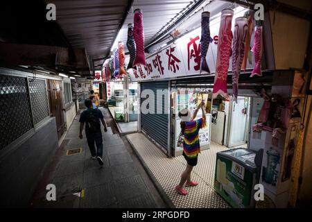 191012 -- HONGKONG, 12. Oktober 2019 -- Kate Lee schließt ihr Teestaurant nach Geschäftszeiten in Kowloon, Südchinesisches Hongkong, 11. Oktober 2019. Eingebettet in den labyrinthartigen Fischmarkt des ruhigen Fischerdorfes Lei Yue Mun in Hong Kong, ist ein kleines, gemütliches Teestaurant unerwartet zu einem Leuchtturm des Mutes für gewöhnliche Menschen in Hongkong geworden, die Frieden inmitten des Chaos der letzten Zeit suchen. Nachdem sie Ende Juni Bilder postete, die die Polizei Hongkongs gegen einige radikale Demonstranten unterstützten, fand Kate Lee, die Besitzerin des Teestaurants, dass ihr Gewissen ihren Familienbetrieb stark belastet hatte. Con Stockfoto