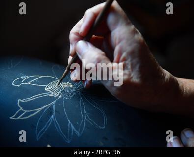 191013 -- POYANG, 13. Oktober 2019 -- Ding Guokun malt in seinem Haus im Poyang County, ostchinesische Provinz Jiangxi, 12. Oktober 2019 auf ein Stück Lackware. Ding Guokun, 76, ein immaterieller Erbe auf nationaler Ebene, stellt seit seinem 16. Lebensjahr körperlose Lackwaren her. Tun Sie weiter etwas und tun Sie es gut. Du wirst irgendwann die Anerkennung der Menschen verdienen, sagt Ding. MASTEROFCRAFTS CHINA-JIANGXI-POYANG-BODILESS LACKWARE CN HUXCHENHUAN PUBLICATIONXNOTXINXCHN Stockfoto