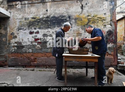 191013 -- POYANG, 13. Oktober 2019 -- Ding Guokun und sein Auszubildender arbeiten in seinem Haus im Poyang County, ostchinesische Provinz Jiangxi, 12. Oktober 2019. Ding Guokun, 76, ein immaterieller Erbe auf nationaler Ebene, stellt seit seinem 16. Lebensjahr körperlose Lackwaren her. Tun Sie weiter etwas und tun Sie es gut. Du wirst irgendwann die Anerkennung der Menschen verdienen, sagt Ding. MASTEROFCRAFTS CHINA-JIANGXI-POYANG-BODILESS LACKWARE CN HUXCHENHUAN PUBLICATIONXNOTXINXCHN Stockfoto