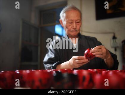 191013 -- POYANG, 13. Oktober 2019 -- Ding Guokun untersucht neu hergestellte Lackwaren in seinem Haus im Poyang County, ostchinesische Provinz Jiangxi, 12. Oktober 2019. Ding Guokun, 76, ein immaterieller Erbe auf nationaler Ebene, stellt seit seinem 16. Lebensjahr körperlose Lackwaren her. Tun Sie weiter etwas und tun Sie es gut. Du wirst irgendwann die Anerkennung der Menschen verdienen, sagt Ding. MASTEROFCRAFTS CHINA-JIANGXI-POYANG-BODILESS LACKWARE CN HUXCHENHUAN PUBLICATIONXNOTXINXCHN Stockfoto