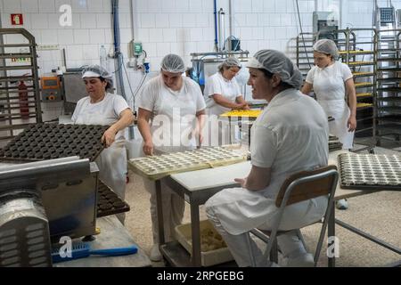 Bäckerinnen bereiten Queijadas, ein traditionelles Pudding-Gebäck, in der Queijadas do Morgado Bäckerei und im Café in Vila Franca do Campo auf der Insel Sao Miguel auf den Azoren, Portugal zu. Die Kuchen wurden im 16. Jahrhundert von Nonnen kreiert und als Queijadas de Vila Franca bezeichnet. Stockfoto