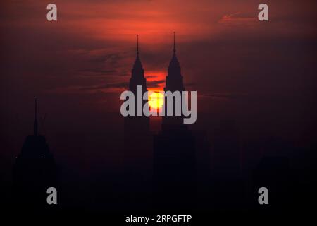 191015 -- PEKING, 15. Oktober 2019 -- die Sonne geht aus der Richtung zwischen den Petronas Twin Towers in Kuala Lumpur, Malaysia, 14. Oktober 2019 auf. Foto von /Xinhua XINHUA FOTOS DES TAGES ChongxVoonxChung PUBLICATIONxNOTxINxCHN Stockfoto