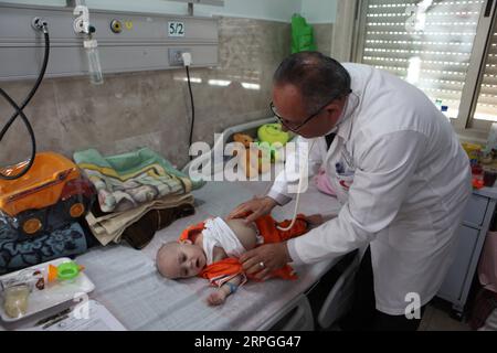 191015 -- HEBRON, 15. Oktober 2019 Xinhua -- Ein Arzt untersucht Mohammed Muheisen, ein palästinensisches Baby aus dem Gazastreifen, das an einer Lungenerkrankung und einem gebrochenen Bein leidet, im Red Crescent Hospital in der Westbank-Stadt Hebron, 15. Oktober 2019. Das neun Monate alte Baby, das im September aus Gaza durch Israel zur Behandlung gebracht wurde, wurde von Freiwilligen betreut, nachdem seiner Mutter angeblich eine Reiserlaubnis verweigert wurde. Foto von Mamoun Wazwaz/Xinhua MIDEAST-HEBRON-BABY-HEALTH PUBLICATIONxNOTxINxCHN Stockfoto