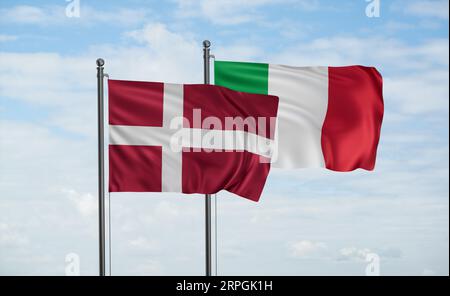 Die Flagge Italiens und Dänemarks weht im Wind am blauen Himmel zusammen, zwei Konzepte der Länderzusammenarbeit Stockfoto