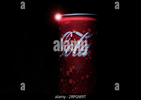 Das Coca-Cola-Getränk auf schwarzem Hintergrund, mit Objektivfackeln, Makrofotografie. 07.28.2023 Stockfoto