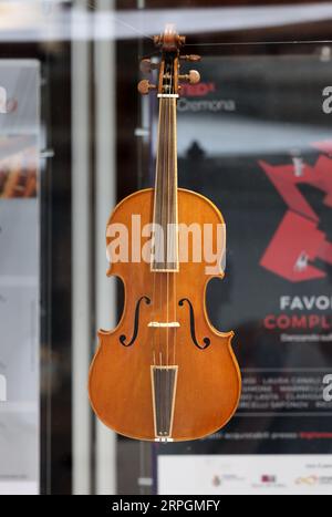 Cremona, Italien - 7. September 2022: Schaufenster eines Luthiergeschäfts in Cremona. Handgemachte Violinen auf dem Display. Stockfoto