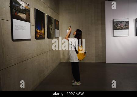 191019 -- JINGDEZHEN, 19. Oktober 2019 -- Eine Frau besucht Eine Fotoausstellung während einer Keramikmesse in Jingdezhen, ostchinesische Provinz Jiangxi, 18. Oktober 2019. Die fünftägige China Jingdezhen International Ceramic Fair 2019 wurde am Freitag eröffnet und zog fast 1.000 Porzellanfirmen aus dem in- und Ausland an. CHINA-JIANGXI-JINGDEZHEN-INTERNATIONAL CERAMIC FAIR CN ZHOUXMI PUBLICATIONXNOTXINXCHN Stockfoto