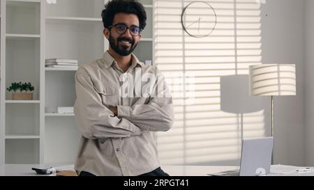 Business Porträt Indischer Araber Mann bärtig männlich freischaffende Führungskraft Spezialist gekreuzt Arme in Home Office glücklich muslimischen Millennials Mann anschauen Stockfoto