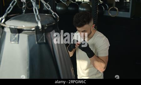 Ansicht von oben Kaukasischer Boxer Champion MMA Profi-Boxer Mann Boxsack in Sportclub männlicher Sportler Trainingsbox Faust Kraft Hard Hit Punching Stockfoto