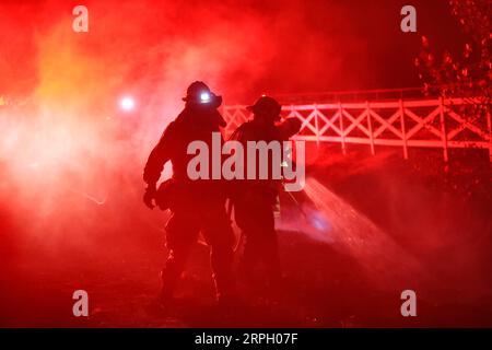 191025 -- LOS ANGELES, 25. Oktober 2019 -- Feuerwehrleute arbeiten an einem Brandherd in Santa Clarita, dem US-Bundesstaat Kalifornien, 24. Oktober 2019. Am Donnerstag brannten in Kalifornien Dutzende von Gebäuden nieder und Zehntausende von Einwohnern mussten ihre Häuser evakuieren. U.S.-CALIFORNIA-WILD FIRE LixYing PUBLICATIONxNOTxINxCHN Stockfoto