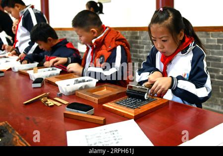 191031 -- JINAN, 31. Oktober 2019 -- Schüler der Xixian Grundschule erleben beweglichen Druck im Lubei Immaterielles Kulturerbe im Wudi County, ostchinesische Provinz Shandong, 30. Oktober 2019. Das Erlebniszentrum bietet eine Vielzahl von immateriellen Kulturerbe-Erlebnisprogrammen, einschließlich der Kunst des Reibens, der Keramik, des Bindefärbens, der Papierherstellung und des beweglichen Drucks, mit dem Ziel, die traditionelle chinesische Kultur durch immersives Erlebnis zu fördern. CHINA-SHANDONG-JINAN-IMMATERIELLES KULTURERBE-ZENTRUM CN ZHUXZHENG PUBLICATIONXNOTXINXCHN Stockfoto