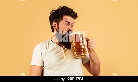 Oktoberfest. Bierzeit. Craft-Bier im Restaurant. Bärtiger Mann trinkt Fassbier in Pub oder Bar. Deutsche Tradition. Überraschter Mann mit einer Tasse Stockfoto