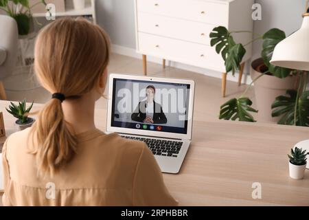 Junge Frau, die zu Hause online ein Bewerbungsgespräch hat Stockfoto
