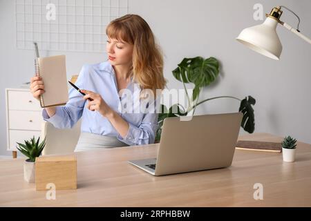 Junge Frau mit Notebook, die zu Hause online ein Vorstellungsgespräch führt Stockfoto