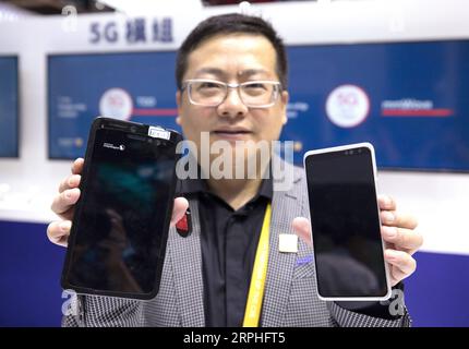 191107 -- SHANGHAI, 7. November 2019 -- Ein Mitarbeiter von Qualcomm präsentiert 5G-Geräte auf dem Sci-Tech Life Ausstellungsgelände während der zweiten China International Import Expo CIIE in Shanghai, Ostchina, am 7. November 2019. CIIE CHINA-SHANGHAI-CIIE-TECHNOLOGIE JinxLiwang PUBLICATIONxNOTxINxCHN Stockfoto