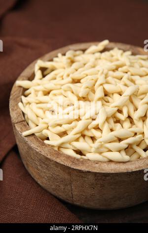 Rohe Trofie-Pasta in Schüssel auf Tisch, Nahaufnahme Stockfoto