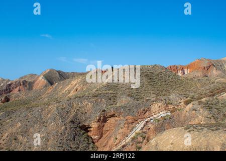 Regenbogen-Berglandschaft im Binggou Danxia Scenic Area von Zhangye Danxia China. Blauer Himmel bei Sonnenuntergang mit Platz zum Kopieren von Text Stockfoto