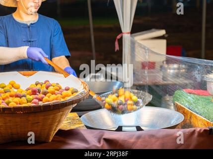 Kochen Süßkartoffelkugel frittiert in einer heißen Pfanne, hergestellt aus Süßkartoffeln und Mehlschimmelkugel. Stockfoto