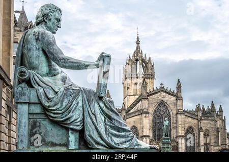 Bronzeskulptur von David Hume und St Giles' Chathedral auf der Royal Mile in Edinburgh, Schottland Stockfoto
