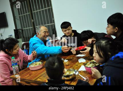 191126 -- NANCHANG, 26. November 2019 -- He Xingwu hat Abendessen mit Studenten in der Sanlian Special Education School in Nanchang, Ostchinesische Provinz Jiangxi, 21. November 2019. Xingwu, Hörgeschädigter, ist Lehrer an der Sanlian Special Education School, die 1994 gegründet wurde. Fünf Jahre später verstarb die Gründerin. Um hörgeschädigten Kindern den Zugang zu Bildung zu ermöglichen, entschloss er sich, alle Aufgaben innerhalb der Schule zu übernehmen. Seine Frau He Runmei, ebenfalls hörgeschädigt, widmete sich der Schule und begann, sich um den Alltag der Kinder zu kümmern. Berücksichtigung der familiären Bedingungen der Schüler Stockfoto