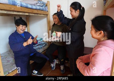 191126 -- NANCHANG, 26. November 2019 -- He Runmei kommuniziert mit Studenten in Nanchang, ostchinesische Provinz Jiangxi, 22. November 2019. Xingwu, Hörgeschädigter, ist Lehrer an der Sanlian Special Education School, die 1994 gegründet wurde. Fünf Jahre später verstarb die Gründerin. Um hörgeschädigten Kindern den Zugang zu Bildung zu ermöglichen, entschloss er sich, alle Aufgaben innerhalb der Schule zu übernehmen. Seine Frau He Runmei, ebenfalls hörgeschädigt, widmete sich der Schule und begann, sich um den Alltag der Kinder zu kümmern. In Anbetracht des familiären Zustands der Schüler war die Studiengebühr minimal Stockfoto