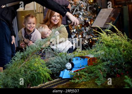 191127 -- NEW YORK, 27. November 2019 -- Besucher posieren für ein Selfie neben dem Modellzug Thomas the Tank Engine auf der Holiday Train Show im New York Botanical Garden in New York, USA, 26. November 2019. Der New York Botanical Garden beginnt mit seiner jährlichen Zugausstellung in die Weihnachtszeit. In der 28. Auflage der Veranstaltung werden die Besucher in eine Miniaturmetropole entführt, während Modellzüge durch eine bezaubernde Ausstellung von mehr als 175 Sehenswürdigkeiten in New York City fahren, die jeweils mit Rinde, Lotusschoten, Eicheln, Zimtstäbchen und anderen natürlichen Materialien nachgebaut wurden. In diesem Jahr Stockfoto