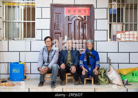 191129 -- KUNMING, 29. November 2019 -- Villager Zhang Jianwei, seine Mutter Huang Lanfangand Vater Zhang Guoxiang posieren für ein Gruppenfoto vor seinem neuen Haus in Luhua Dorf Xijiekou Stadt, Shilin Yi Autonomous County, Südwestchinesische Provinz Yunnan, 28. November 2019. Zhang baute sein Haus, das zuvor gefährlich war, im Juni 2018 mit Unterstützung der lokalen Regierung wieder auf. Sträucher mit pepino-Melonen breiten sich über der steinigen Wüste im Dorf Luhua im südwestlichen chinesischen Yunnan aus. Es ist das Ergebnis für die Einheimischen, gegen die raue Umwelt zu kämpfen und ein Erfolg, ein besseres Leben zu führen. Am Stockfoto