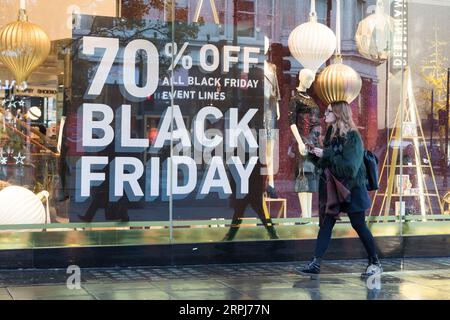 191129 -- LONDON, 29. Nov. 2019 Xinhua -- Eine Frau geht an einem Schaufenster vorbei, an dem Black Friday-Verkäufe in London, Großbritannien, am 29. Nov. 2019 angezeigt werden. Foto von Ray Tang/Xinhua BRITAIN-LONDON-BLACK FRIDAY-SALES PUBLICATIONxNOTxINxCHN Stockfoto