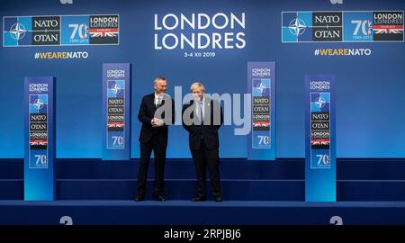 191204 -- LONDON, 4. Dezember 2019 -- NATO-Generalsekretär Jens Stoltenberg L spricht mit dem britischen Premierminister Boris Johnson während der offiziellen Handshake-Zeremonie auf dem NATO-Gipfel der Nordatlantischen Vertragsorganisation in London, Großbritannien am 4. Dezember 2019. BRITISCH-LONDON-NATO-GIPFEL - ANKUNFT HanxYan PUBLICATIONxNOTxINxCHN Stockfoto