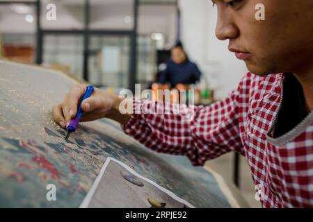 191207 -- PU er, 7. Dez. 2019 -- Student Zhong Xing vom Kunstinstitut macht Jueban Holzschnitt Malerei im Holzschnitt-Studio der Pu er Universität in Pu er Stadt, Südwestchina Provinz Yunnan, 5. Dez. 2019. Der Jueban-Holzschnitt ist eine Art Holzschnitzerei, die aus der Stadt Pu er in den 1980er Jahren stammt CHINA-YUNNAN-PU ER-HOLZSCHNITT-MALEREI CN HUXCHAO PUBLICATIONXNOTXINXCHN Stockfoto