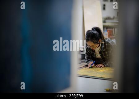 191207 -- PU er, 7. Dez. 2019 -- Student Liu Ying vom Kunstinstitut macht Jueban Holzschnitt Malerei im Holzschnitt-Studio der Pu er Universität in Pu er Stadt, Südwestchina Provinz Yunnan, 5. Dez. 2019. Der Jueban-Holzschnitt ist eine Art Holzschnitzerei, die aus der Stadt Pu er in den 1980er Jahren stammt CHINA-YUNNAN-PU ER-HOLZSCHNITT-MALEREI CN HUXCHAO PUBLICATIONXNOTXINXCHN Stockfoto