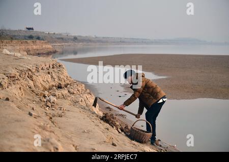 191207 -- ZHENGZHOU, 7. Dezember 2019 -- Li Xiyang, der 7. Generation Erben seiner Familie von Yellow River Chengni, sucht am 6. Dezember 2019 am Strand des Gelben Flusses in der Gemeinde Huagong der Stadt Mengzhou, der zentralchinesischen Provinz Henan, nach Schlamm, um Tintensteine herzustellen. Als einer von Chinas berühmten Tintensteinen wurde der Yellow River Chengni Tintenstein 2007 in der ersten Reihe von immateriellen Kulturerben der Provinz Henan aufgeführt. CHINA-HENAN-MENGZHOU-CHENGNI INKSTONE CN FENGXDAPENG PUBLICATIONXNOTXINXCHN Stockfoto
