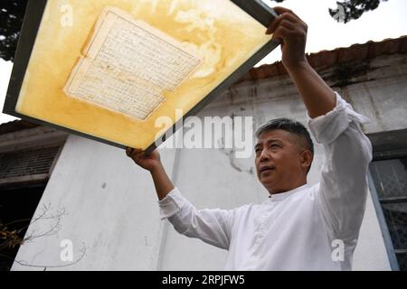 191209 -- JINGXIAN, 9. Dezember 2019 -- Cao Jianqin zeigt reparierte Seiten eines antiken Buches in der Zijinlou Xuan Papierfabrik im Jingxian County, Xuancheng Stadt in der ostchinesischen Provinz Anhui, 22. Oktober 2019. Xuan-Papier, traditionelles chinesisches Papier, das im Jingxian County in der Stadt Xuancheng hergestellt wird, hat eine Geschichte von mehr als 1.000 Jahren. Bei mehr als 100 Verfahren kostet die Herstellung des Papiers mindestens ein Jahr, um das Material in das Endprodukt zu verwandeln. Das Papier ist bekannt für seine ausgezeichnete Handwerkskunst, seine feine Qualität und seine lange Erhaltungszeit und wird von chinesischen Künstlern und Kalligraphen geliebt und wird PA genannt Stockfoto