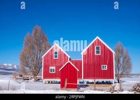 Hellrote Scheune an einem sonnigen Wintertag in der Nähe von Monticello, Utah, USA Stockfoto