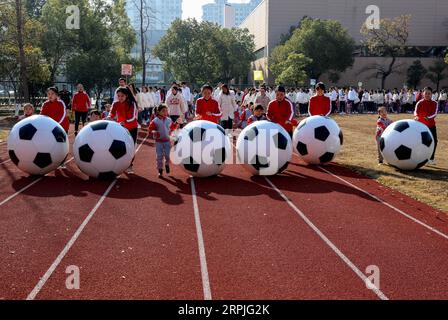 191209 -- CHANGXING, 9. Dezember 2019 -- Schüler und Lehrer spielen Spiele mit riesigen Fußbällen während einer Fußballaktivität in einem Kindergarten im Bezirk Changxing der ostchinesischen Provinz Zhejiang, 9. Dezember 2019. CHINA-ZHEJIANG-CHANGXING-FUN GAMES-FOOTBALL CN XUXYU PUBLICATIONXNOTXINXCHN Stockfoto