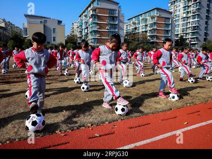 191209 -- CHANGXING, 9. Dez. 2019 -- Schüler spielen mit Fußbällen während einer Fußball-Aktivität in einem Kindergarten im Bezirk Changxing der ostchinesischen Provinz Zhejiang, 9. Dez. 2019. CHINA-ZHEJIANG-CHANGXING-FUN GAMES-FOOTBALL CN XUXYU PUBLICATIONXNOTXINXCHN Stockfoto