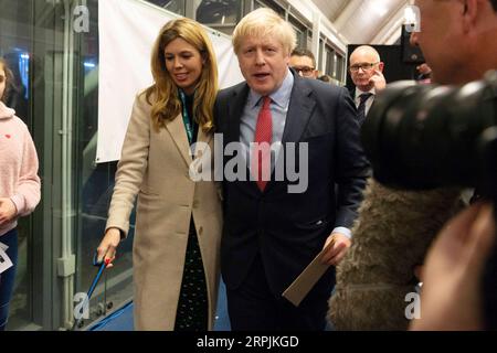 191213 -- LONDON, 13. Dezember 2019 Xinhua -- der britische Premierminister und Parteivorsitzende Boris Johnson R verlässt mit seiner Partnerin Carrie Symonds L nach der Stimmerklärung in Uxbridge, London, Großbritannien, 13. Dezember 2019. Eine Ausstiegsumfrage, die veröffentlicht wurde, nachdem die Abstimmung bei den britischen Wahlen am Donnerstagabend geschlossen wurde, deutet darauf hin, dass die Konservativen auf dem Weg sind, eine massive parlamentarische Mehrheit zu gewinnen. Foto von Ray Tang/Xinhua GROSSBRITANNIEN-LONDON-GENERAL ELECTION-VOTES COUNT-BORIS JOHNSON PUBLICATIONxNOTxINxCHN Stockfoto