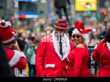 191214 -- NEW YORK, 14. Dezember 2019 -- Menschen posieren für ein Foto während der SantaCon 2019 in New York, USA, 14. Dezember 2019. In Weihnachtsmannkostümen oder festlichen Kostümen versammelten sich am Samstag Hunderte von Menschen auf dem Times Square zur SantaCon 2019, um die weihnachtliche Atmosphäre zu genießen und Geld für wohltätige Zwecke zu sammeln. U.S.-NEW YORK-2019 SANTA CON WangxYing PUBLICATIONxNOTxINxCHN Stockfoto