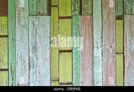 Alte Holzwand, alte gemalte Holzwand mit mehrfarbigem Landschaftsbild. Stockfoto