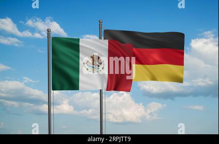 Deutsche Flagge und mexikanische Flagge, die am blauen Himmel zusammenwinken, zwei Länderkooperationskonzept Stockfoto