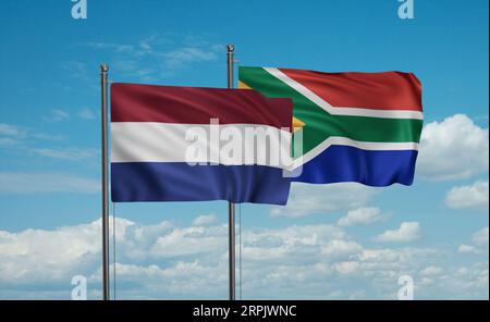 Die Flagge der Republik Südafrika und der Niederlande weht im Wind am blauen Himmel zusammen, zwei Konzepte der Länderzusammenarbeit Stockfoto
