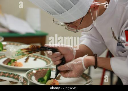 191221 -- BELGRAD, 21. Dezember 2019 -- Ein chinesischer Student, Der sich mit kulinarischen Künsten beschäftigt, bereitet kalte Gerichte während einer traditionellen chinesischen Kochshow in Belgrad, der Hauptstadt Serbiens, am 20. Dezember 2019 zu. Am Freitag fand in Belgrad eine traditionelle chinesische Kochshow statt, bei der 10 Studenten des Tourism College of Zhejiang, die sich mit kulinarischen Künsten beschäftigen, während dieser Aktivität für Besucher kochen. SERBIEN-BELGRAD-CHINA-TRADITIONELLE KÜCHE-SHOW SHIXZHONGYU PUBLICATIONXNOTXINXCHN Stockfoto