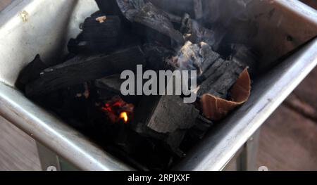 Holzkohlestücke auf einem Grillherd, die ein Feuer zum Kochen oder Braten von Fleisch anzünden Stockfoto