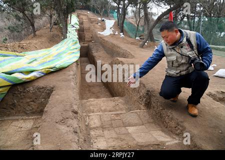 191222 -- QINGDAO, 22. Dezember 2019 -- ein Archäologe erklärt einen gepflasterten Pfad, der am 21. Dezember 2019 bei den Langyatai-Ruinen in der Stadt Qingdao in der ostchinesischen Provinz Shandong entdeckt wurde. Ein Entwässerungssystem aus den Dynastien Qin 221-206 v. Chr. und Han 206 v. Chr. bis 220 n. Chr. wurde in den Ruinen von Langyatai entdeckt. Im Oktober dieses Jahres begannen die Ausgrabungen an zwei Stellen der Ruinen. Bisher wurden ein Erdplattform-Fundament, ein Entwässerungssystem und eine Gebäudebasis entdeckt, die sich in großem Maßstab befinden und über rigoroses architektonisches Handwerk verfügen. CHINA-SHANDONG-QINGDAO-LANGYATAI-ARCHÄOLOGISCHE SCHEIBE Stockfoto