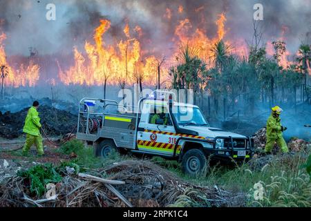 Rettungsdienste Feuerwehrmänner, die arbeiten, um einen Fluchtort zu kontrollieren kontrollierte Gefahrenreduzierung brennen in der Buschland am Stadtrand von Darwin. Stockfoto