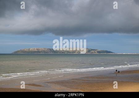 Strand in Penmaenmawr in Nordwales, mit Blick auf Llandudno und den Great Orme, an einem angenehmen Sommerabend. Stockfoto