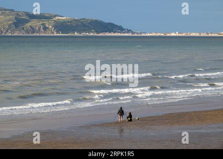 Leute fischen am Strand in Nordwales, mit Landudno und dem Great Orme in der Backgroup. Wales, Großbritannien. Stockfoto