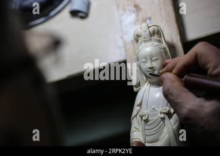 191226 -- PEKING, 26. Dezember 2019 -- Li Chunke macht eine Schnitzerei auf Mammutzahn in einer Werkstatt des Pekinger Polytechnikum für Leichtindustrie in Peking, Hauptstadt von China, 25. Dezember 2019. Zahnschnitzerei, ursprünglich Schnitzen auf Elfenbein, ist eine traditionelle Kunst im alten China. Es stellte den Höhepunkt der Volkskunst in China während der Qing-Dynastie 1644-1911 dar und wurde in der Dekoration für den königlichen Hof populär. China hat seine Bemühungen im Bereich des Schutzes der wildlebenden Tiere im Laufe der Jahre verstärkt. Am 31. Dezember 2016 erklärte China, es werde innerhalb eines Jahres eine vollständige Einstellung seines inländischen Elfenbeinhandels durchsetzen. Auf D Stockfoto